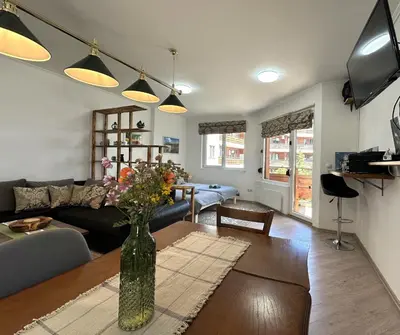 a living room with a vase of flowers on a table at Cosy 2-bedroom apartment near the ski road Bansko in Bansko