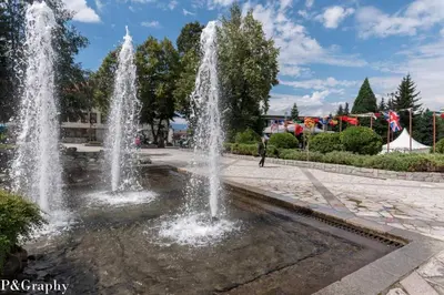 a fountain with two fountains in a park at Cosy 2-bedroom apartment near the ski road Bansko in Bansko