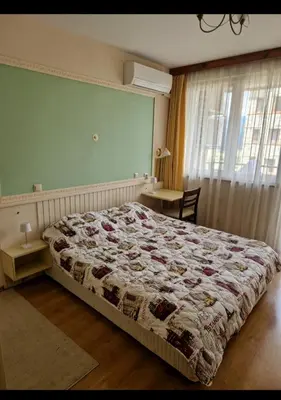 a bedroom with a bed and a table and a window at Pirin Golf Hotel & Spa in Razlog