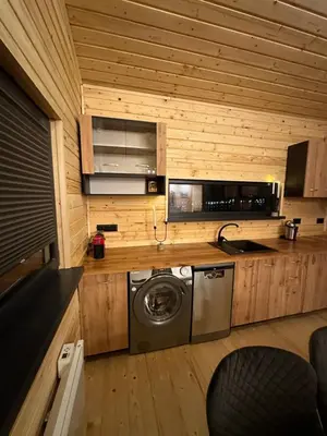 a kitchen with a washing machine in a room at Stylish Alpine Ski Chalet Tirol in Borovets