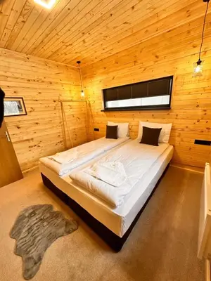 a bedroom with a large bed in a wooden room at Stylish Alpine Ski Chalet Tirol in Borovets