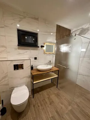 a bathroom with a sink and a toilet and a television at Stylish Alpine Ski Chalet Tirol in Borovets