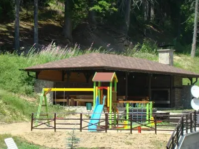 a playground in front of a building with a slide at Sun Stream Apartment in Pamporovo