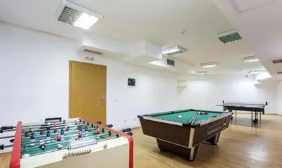 a room with a pool table and two tables at Alenik Private Apartment -The Stream Resort Pamporovo in Pamporovo
