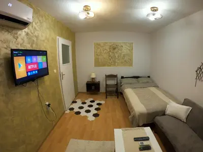 a bedroom with a bed and a flat screen tv at Mini Quiet Central Studio in Pazardzhik