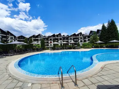 a swimming pool at a resort with chairs and umbrellas at Aspen Resort Studio I306 in Razlog