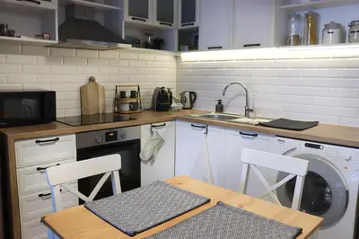 a kitchen with a washing machine and a table and chairs at Classy Residential 1BDRM Flat With View and Elevator in Sofia