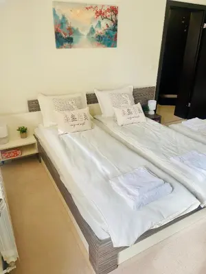 a large bed with white sheets and pillows on it at Snow Forest in Borovets