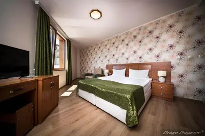 a bedroom with a bed and a flat screen tv at SPA Hotel Elbrus in Velingrad