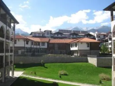 a group of buildings with a green lawn in front of it at 27 Monastery in Bansko