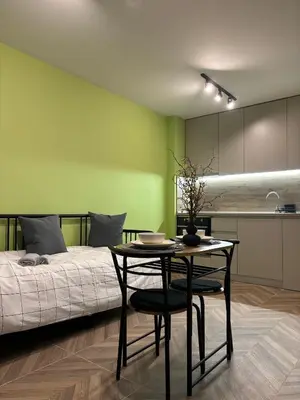a bedroom with a bed and a table and a kitchen at Inspiration Nook in Sofia