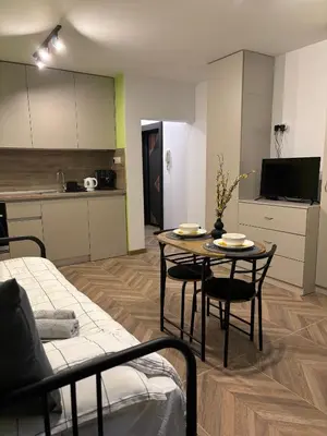 a living room with a table and a kitchen at Inspiration Nook in Sofia