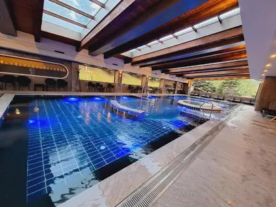 a large swimming pool in a large building at Slopes View Private Apartment - Luxury SPA in the 4-Star St Ivan Rilski Complex in Bansko