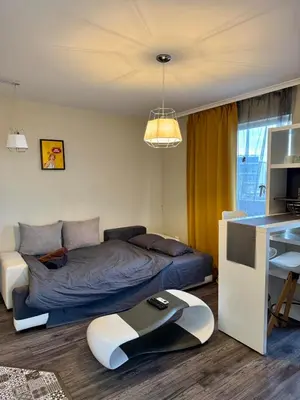 a bedroom with a bed and a table in it at New Bulgarian Apartment in Sofia