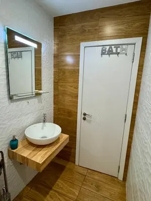 a bathroom with a sink and a white door at New Bulgarian Apartment in Sofia