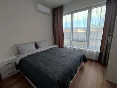 a bedroom with a bed and a large window at Pana Green Residence in Panagyurishte