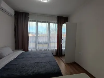 a bedroom with a bed and a large window at Pana Green Residence in Panagyurishte