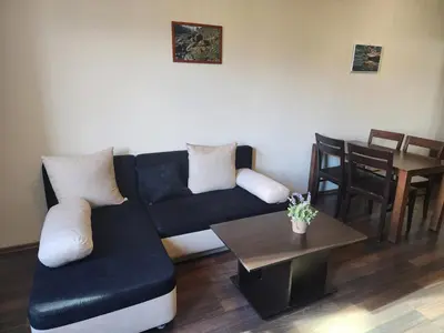 a living room with a couch and a table at Pirin View Apartment in Bansko
