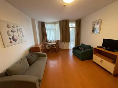 a living room with a couch and a television and a table at FLORA Apartment Hotel 412 in Borovets
