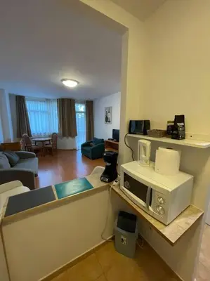 a living room with a microwave on a counter at FLORA Apartment Hotel 412 in Borovets