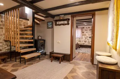 a living room with a wooden staircase and a stair case at Гусу Баба in Kostenets Village