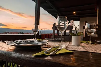 a table with glasses and plates and utensils on at Гусу Баба in Kostenets Village