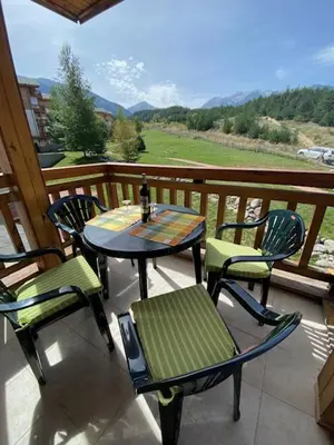 a patio with a table and chairs on a balcony at St John Hill Alexander Services Apartments in Bansko