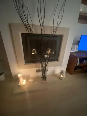 a vase with flowers and candles in a living room at St John Hill Alexander Services Apartments in Bansko