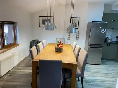 a kitchen with a wooden table with chairs and a refrigerator at Elegant 3 Alexander Services Apartments luxury four bedroom penthouse in Bansko