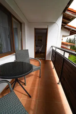 a balcony with a table and chairs on a balcony at CrosswayBg Pamporovo in Pamporovo