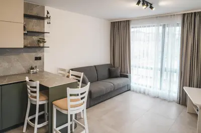 a kitchen and living room with a couch and a table at Apartment Aria 3 in Velingrad