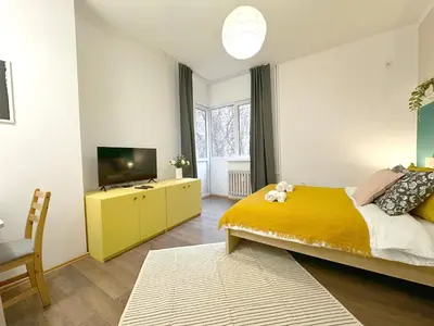 a bedroom with a yellow bed and a television at Aurora Abode - Top Center 1 BDR Fast Wi-fi in Sofia