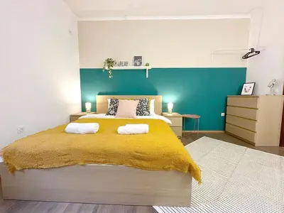 a bedroom with a large bed with a yellow blanket at Aurora Abode - Top Center 1 BDR Fast Wi-fi in Sofia