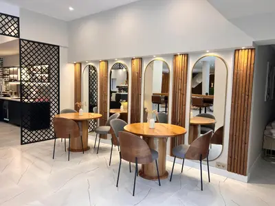 a restaurant with two tables and chairs and mirrors at Designer apartment at Pirin Sense in Bansko