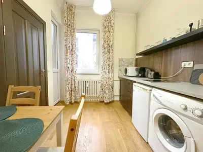 a kitchen with a washing machine and a table at Echoes of Comfort - Top Center 1 BDR Fast Wi-fi in Sofia