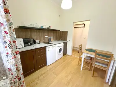 a kitchen with a washing machine and a table and chairs at Echoes of Comfort - Top Center 1 BDR Fast Wi-fi in Sofia