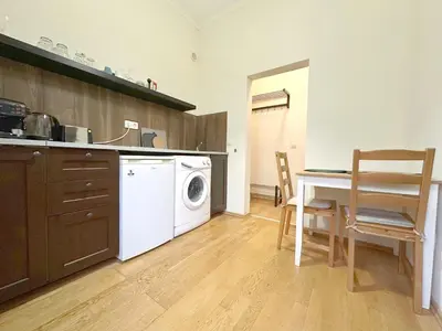 a kitchen with a washing machine and a table and chairs at Echoes of Comfort - Top Center 1 BDR Fast Wi-fi in Sofia