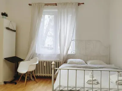 a bedroom with a bed and a window and a chair at Apartment for four next to blvd Vitosha in Sofia