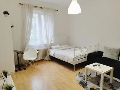 a bedroom with a bed and a couch and a table at Apartment for four next to blvd Vitosha in Sofia