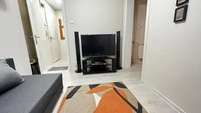 a living room with a couch and a flat screen tv at Great location in the Center in Sofia
