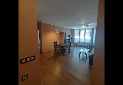 a living room and dining room with a table and chairs at GONDOLA APARTMENTS BANSKO - SUVOROV VIP Complex in Bansko