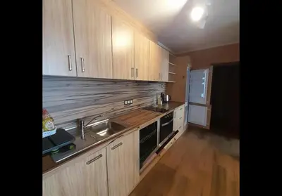 a kitchen with wooden cabinets and a sink at GONDOLA APARTMENTS BANSKO - SUVOROV VIP Complex in Bansko
