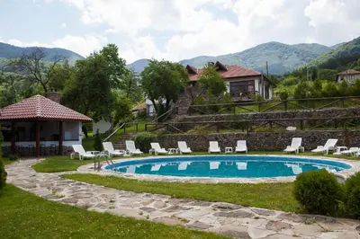 a swimming pool with chairs and a house at Самостоятелна къща за гости с изглед към планината Вила Марк in Kraevo