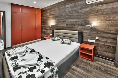 a bedroom with a bed and a wooden wall at Hotel Elit in Sandanski