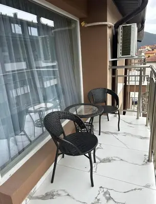 two chairs and a table on a balcony with snow at Nikos Apatament in Velingrad