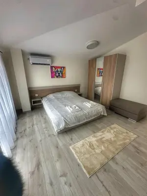 a bedroom with a bed and a rug on the floor at Nikos Apatament in Velingrad