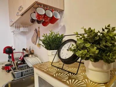 a kitchen counter with a clock and potted plants at Mountain View Studio, Steps from Bansko Gondola by Flat Mаnager in Bansko