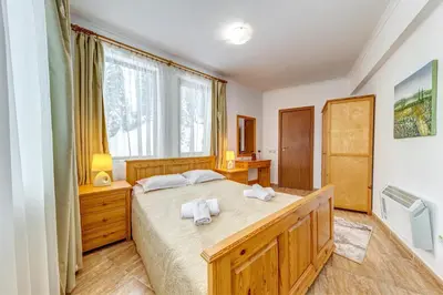 a bedroom with a large bed with two towels at Alpine Haven 2-Bedroom Escape, Pamporovo by Flat Mаnager in Pamporovo