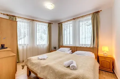 a bedroom with a large bed with towels on it at Alpine Haven 2-Bedroom Escape, Pamporovo by Flat Mаnager in Pamporovo