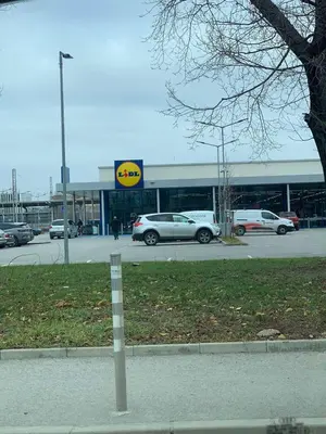a parking lot with cars parked in front of a store at 5 min from the Airport in Sofia